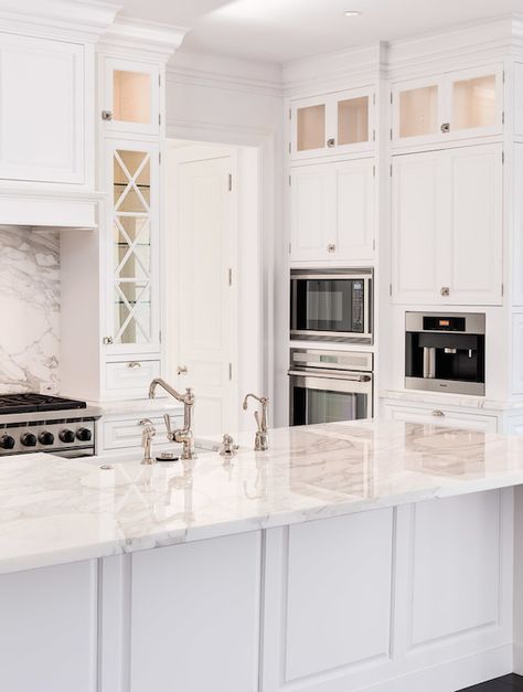 Stunning white kitchen with cooking alcove filled with a solid marble backsplash between a paneled range hood and a stainless steel stove. Cooking Alcove, Florida Kitchen Ideas, White Transitional Kitchen, Stainless Appliances Kitchen, Small White Kitchens, Transitional Kitchens, Kitchen Planning, White Shaker Kitchen, Classic White Kitchen