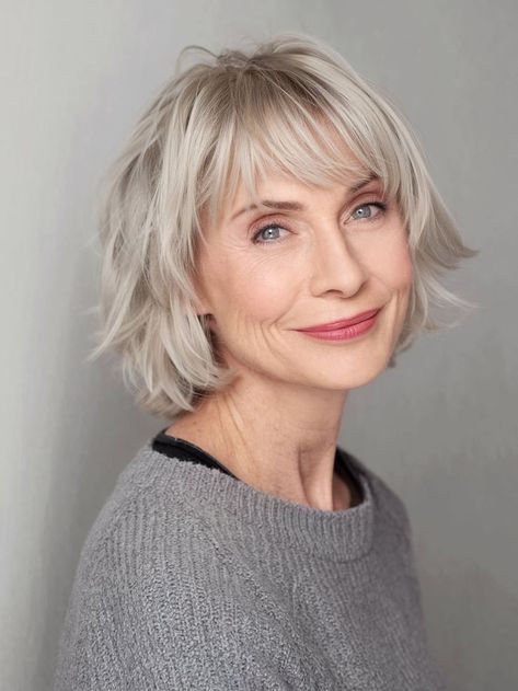 Embrace a youthful vibe with this textured shag cut, enhanced by wispy bangs. The layered style adds volume and movement, making it perfect for those with fine hair. This fall haircut suits women over 70, providing a soft, face-framing look that complements the natural gray or silver hues beautifully. Pixie Bob Curly, Short Gray Pixie, Shag With Wispy Bangs, Bangs For Older Women, Fall Haircut, Gray Pixie, Fall Hair Cuts, Modern Fall, Wispy Bangs