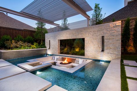 This modern and luxurious swimming pool has a spa with a fireplace, a sunken lounge with a firepit, a cantilevered deck, and floating stepper pads. #SwimmingPool #PoolDesign #LandscapingIdeas #PoolIdeas Sunken Fire Pit, Patio Seating Arrangement, Sunken Patio, Sunken Fire Pits, Moderne Pools, Terrasse Design, Luxury Pools, Modern Pools, Pool Lounge