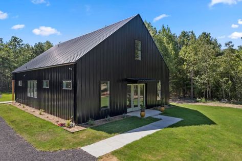 Black Barndo, Texas Barndominium, Stilt Home, Wooden Homes, Black Barndominium, Wooden Trim, Open Living Area, Wooden Front Doors, Grey Exterior