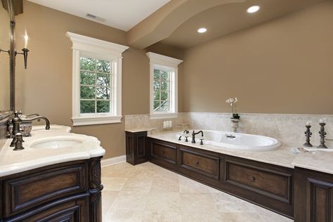 A dual sink vanity faces the deep soaking tub fitted with bronze fixtures. It is illuminated by recessed ceiling lights along with natural light from the white framed windows. Neutral Bathroom Paint, Neutral Bathroom Paint Colors, Color Bathroom Design, Bathroom Wall Colors, Neutral Bathroom, Bathroom Color Schemes, Bathroom Paint Colors, Brown Bathroom, Custom Bathroom