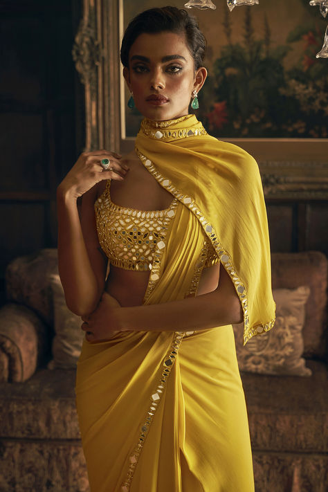 Yellow pre-draped saree in georgette base with an attached petticoat and mirror work. It is paired with an embroidered blouse.  for weddings, engagements or haldi ceremonies. Celebrating Trendsetters Applauding women redefining style, one silhouette at a time.  #Perniaspopupshop #womenswear #ethnic #whatiworewastrending #ppuslove #sareeset #cocktailparty #georgette #mirror #petticoatwork #sareeforwomen #printedsaree #weddingwear Mirror Work Border, Indian Outfits Modern, Yellow Mirror, Seema Gujral, Mirror Work Saree, Mirror Work Blouse Design, Yellow Mirrors, Bridal Sari, Stitched Saree