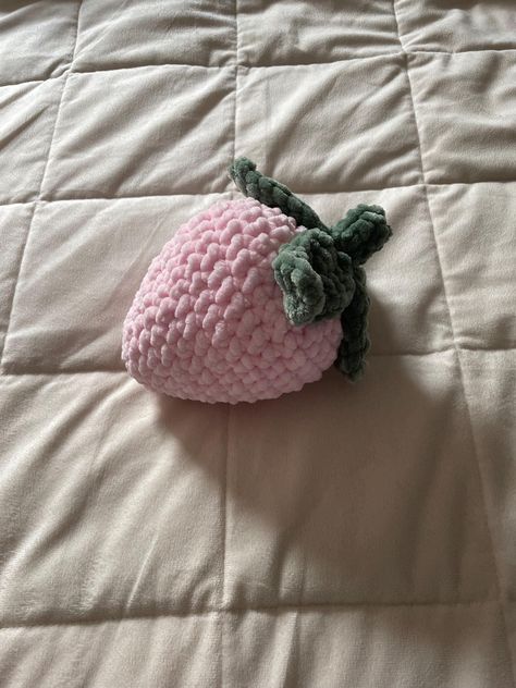 A crocheted strawberry plushie handmade with soft pink or red yarn. Strawberry Plushie Crochet, Pink Crochet Pattern, Pink Yarn Crochet Ideas, Crochet Strawberry Pillow, Red Crochet Ideas, Crochet Useful Items, Cute Pink Crochet, Strawberry Crochet Pattern, Strawberry Plushie