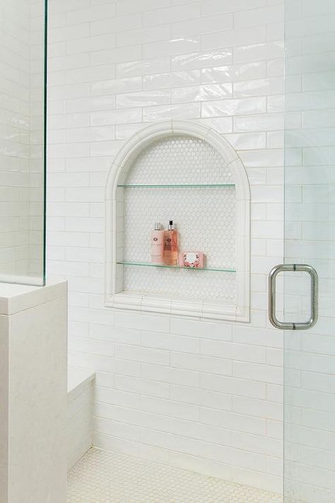 Arched shower niche displaying glass shelves and white hex tiles around a horizontal white glaze tiled wall. Glass Shower Shelf, Big Shower Niche, Shower Niche Glass Shelves, Arch Shower Niche, Arched Shower Niche, Built In Shower Shelves, Tile Shower Niche, Hex Tiles, Tiled Wall