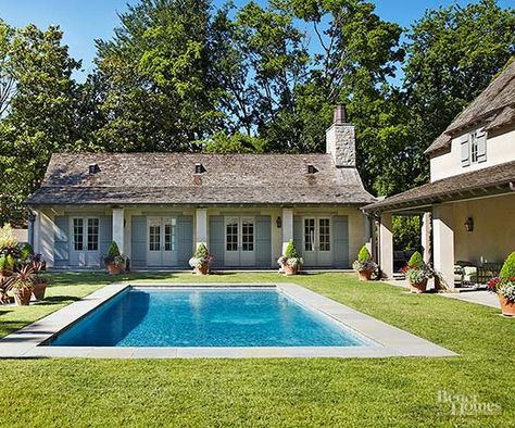 Take inspiration from your home's architecture when designing a backyard pool. Here, a plainly profiled pool with a limestone-tiled deck sits amid a clipped lawn and reflects a country French attitude that echoes the architectural style of the home. The pool deck visually references vertical columns that support a roof that shades a patio area connecting to the home and guesthouse. Hamptons Pool, Country Pool, Paved Patio, Dream Pools, Backyard Pool Designs, Outdoor Entertaining Area, Inviting Home, Pool Patio, In Ground Pools