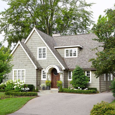 Small details can make a big difference! Bright white trim adds contrast to the warm gray color scheme of this home. More entryway makeovers: http://www.bhg.com/home-improvement/exteriors/curb-appeal/entryway-designs/?socsrc=bhgpin060613wooddoor=4 House Colors With Brown Roof, Brown Roofs, Cape Style Homes, Brown Roof, Tudor Style Homes, Casas Coloniales, Entry Way Design, Exterior Paint Colors For House, House Paint Exterior