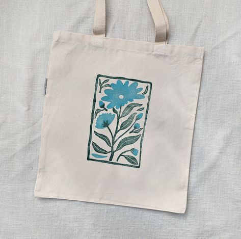 As always, this flower tote bag was printed by hand from hand-carved blocks. The fabric is a durable heavy cotton canvas. Perfect for carrying books, groceries, everyday items, or giving to a friend as a gift! Try using it as a gift bag and fill it with more goodies for the perfect present. Organic Cotton Canvas Printed by hand 14.5x15.5 inches Machine Wash in Cold Water Tumble Dry on Low Heat Iron on Reverse Organic Tote Bag, Block Print Tote Bag, Craft Night Party, Decorated Tote Bags, Tote Bag Painting, Diy Tote Bag Design, Painted Tote Bag, Blue Flower Design, Tot Bag