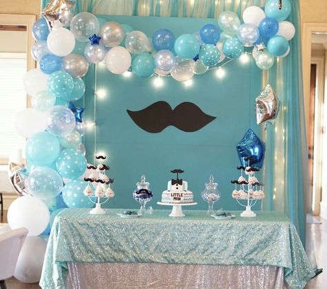 A Mustache Bash baby shower backdrop for a boy. Might also be used for a boy's first birthday party. Little man theme. Balloon garland shades of aqua blue white and silver and a touch of royal blue. Lights on the board and worked into the curtain surrounding make great ambiance for the evening festivities. Elegant Occasions design by Amy Wasmer. Silver blue backdrop Blue White Theme Birthday Party, Aqua Theme Birthday Party, Mustache Decorations, Little Man Birthday Party Ideas, Boy Shower Themes, Mustache Baby Shower, Birthday Decorations For Men, Winter Birthday Parties, Boy Birthday Decorations