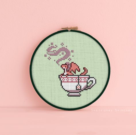 Stitch up a cozy little dragon friend with this tea dragon cross stitch pattern! Nothing better than cozying up with a warn cup of dragon ❤️  This is a DIGITAL DOWNLOAD for a PATTERN ONLY!   There is no physical item with this listing- the image shown is meant as a color example only. You will only receive a digital copy of the shown pattern. The example is a digital mockup.  This listing includes a colored pattern with symbols, a black and white symbol only pattern, and a thread guide in .PDF format. If you need a format other than .PDF, please contact me ★ prior ★ to purchase to ensure I can deliver your request!  🫖 Specifications 🫖 Stitch Dimensions: 48w x 50h Floss Count: 7 Stitch Count: 838  🫖 Finished Size 🫖 14ct - 3.4" w x 3.6" h 16ct - 3.0" w x 3.1" h 18ct - 2.7" w x 2.8" h 22c Small Dragon Cross Stitch, Rude Cross Stitch Patterns Free, Fandom Cross Stitch, Tea Cup Cross Stitch, Cross Stitch Dragon Pattern, Dnd Cross Stitch Patterns Free, Discworld Cross Stitch, Tea Cross Stitch, Nerdy Cross Stitch Patterns