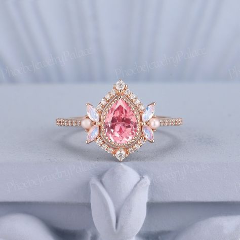 Unique Pink Sapphire Engagement Ring Delicate Pear Wedding Rings for Women Gold Moonstone Pearl Diamond Cluster Cocktail Ring Gift for Her PRODUCT SUMMARY Metal Type: yellow, white or rose solid 14 or 18k gold. Size: All sizes are available, contact me if they do not contain the size you want in the drop-down menu. ☪☪Engagement ring ⚜Center Stone - Lab Peach Pink Sapphire Cut - Pear Size - 7x5mm ⚜Side Stone - Natural Moonstone (Marquise)& Moissanite or Natural Diamond Cut - Round Weight - 0.196c Pink Princess Ring, Pink Engagement Ring Gold, Pink Pear Ring, Pink Diamond Ring Engagement, Engagement Ring Delicate, Rings For Women Gold, Pink Sapphire Engagement Ring, Pink Engagement, Pink Diamond Engagement Ring