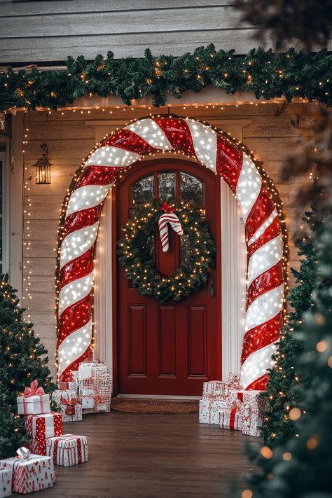 A festive candy cane archway frames a decorated front door with lights, wreaths, garlands, and presents for Christmas. Candy Cane Outdoor Christmas Decorations, Decor With Lanterns, Xmas Projects, Outdoor Garland, Outdoor Christmas Decoration Ideas, Candy Cane Decorations, Christmas Decoration Ideas, Christmas Porch Decor, Festival Diy