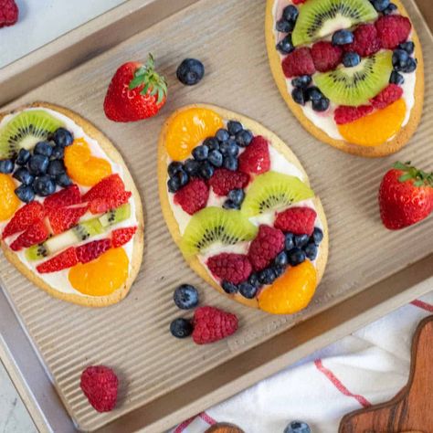 Celebrate spring with these fun and easy Easter egg fruit pizza cookies! Sugar cookies topped with a delicious cream cheese frosting and seasonal fruit and berries! They are as delicious as they are beautiful! Egg Fruit Pizza, Easter Fruit Pizza, Easter Egg Fruit Pizza, Easter Egg Dessert, Mini Dessert Easy, Fruit Pizza Cookies, Egg Fruit, Egg Shaped Cookies, Fruit Sugar Cookies