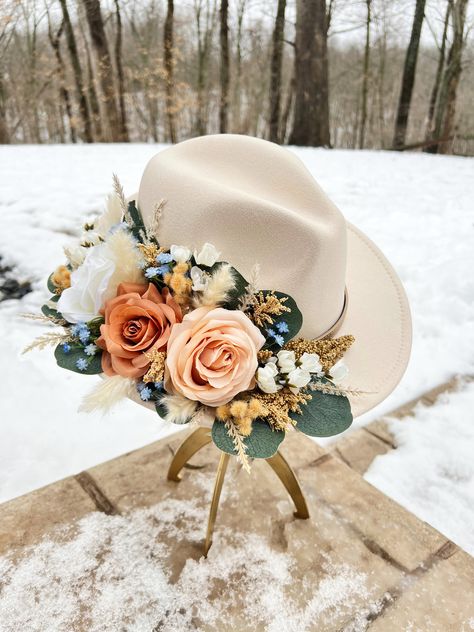 This beautiful boho hat features gorgeous blush pink and dusty blue flowers and gives off that fresh summer bridal look. This is perfect for bridal showers, engagement parties, bachelorette trips, or a beautiful wedding!  Personalization is free on this item, and if you would like a custom version of this hat please email aaivorybrides@gmail.com Hat For Wedding For Women, Bridesmaid Cowgirl Hats, Wedding Cowgirl Hat For Bride, Bridal Fedora Hat, Wedding Fedora Bride, Cowgirl Hat With Flowers, Boho Wedding Hat, Felt Hat Diy, Wedding Hats For Bride