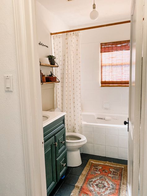 Our mini bathroom makeover gave us the neutral boho bathroom of our dreams (or at least one that'll hold us over until a remodel). With a painted moody green vanity, painted tile, beige beadboard and wood ac cents, this neutral boho bathroom was a game-changer in our little home. #neutralbohobathroom #bohobathroomdecor #neutralbathroomdecor #turkishrugbathroom #juterugbathroom #beadboardbathroom #greenbathroomvanity #openshelvesbathroom #bohobathroomideas Dingy Bathroom, Paint Bathroom Tile, Painting Bathroom Tiles, Paint Bathroom, Sweat Equity, Budget Bathroom Remodel, Small Bathroom Ideas On A Budget, Casa Vintage, Boho Bathroom