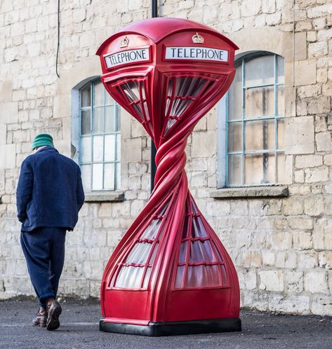 a man in a blue corduroy outfit walks by a bright red telephone boot with an exaggerated twist at the center Installation Street Art, 1950s Art, Urban Intervention, Food Sculpture, Public Artwork, Public Sculpture, Modern Crafts, Nature Drawing, Sculpture Installation