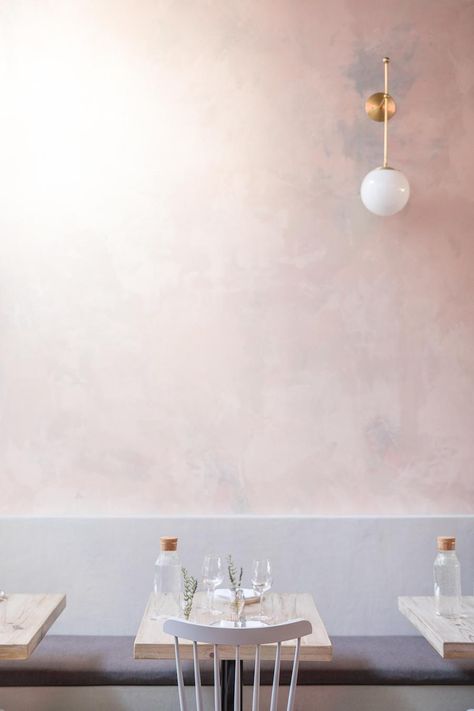 A subtly-pink wall and pastel-painted chairs. On each table: a cork-top glass water bottle and fresh herbs. Putz Hacks, Limewash Walls, Limewash Paint, Wall Texture, Painted Chairs, Luxury Homes Interior, Pink Wall, Plaster Walls, Silver Lake