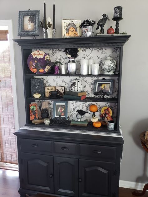 Witchy China Hutch, Halloween Hutch Decor, Bookcase With Wallpaper Backing, Painted Hutch Ideas, Kitchen Hutch Decor, Black Hutch, Black Shabby Chic, Bookshelf Makeover, Bookcase Makeover