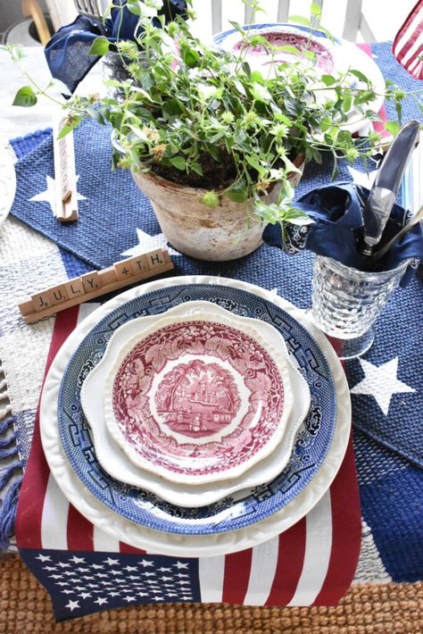 This red, white and blue tablescape is perfect for a Memorial Day, July 4th or Labor Day party. Layered blue transferware, red transferware and basic white plates were perfect for this patriotic themed table. I love how the flag "placemats" turned out and the thrifted layered rugs I used for table runners. And a vase filled with baseballs definitely screams SUMMER. This tablescape is perfect for a Memorial Day, July 4th or Labor Day party. American Flag Dessert, White And Blue Tablescape, Flag Desserts, Blue Tablescape, July 4th Holiday, Blue Centerpieces, Small Flags, Transferware Plate, Fourth Of July Decor