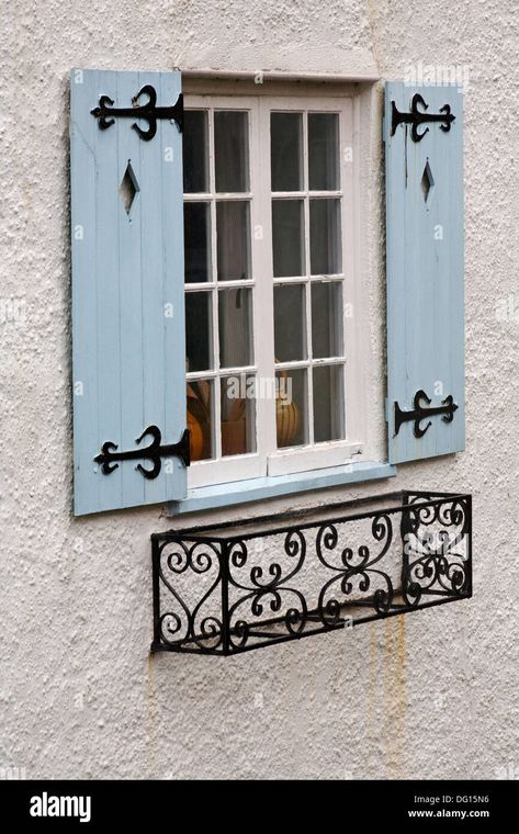 Download this stock image: window with light blue wooden shutters and wrought iron window box at Lyme Regis, Dorset UK in August - DG15N6 from Alamy's library of millions of high resolution stock photos, illustrations and vectors. Light Blue Shutters, Jendela Vintage, Outdoor Window Shutters, Wrought Iron Window Boxes, Wrought Iron Window, درابزين السلم, Window Shutters Exterior, Outdoor Shutters, House Shutters