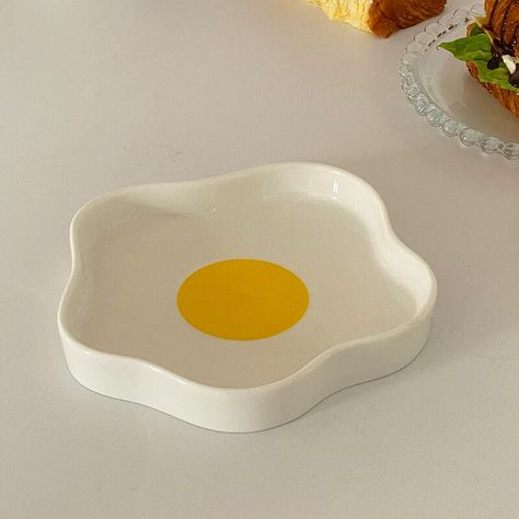 The Fried Egg Shaped Ceramic Plate is a fun and practical addition to any breakfast table, resembling a sunny-side-up fried egg. Its playful design and high-quality ceramic construction make it a must-have for anyone who loves creative kitchen accessories. DETAIL - Item No: 202305DP13 - Material: Ceramic - Package include: Plate*1 NOTE Suitable for ovens, disinfection cabinets, dishwashers, microwave ovens CLEANING & MAINTENANCE Cleaning ceramic dinnerware requires a gentle touch to avoid damagi Cute Ceramic Plates, Ceramic Ideas Pottery, Easter Ceramics, Fun Ceramics, Plate Clay, Ceramic Plates Designs, Egg Ceramic, Egg Mug, Ceramic Egg