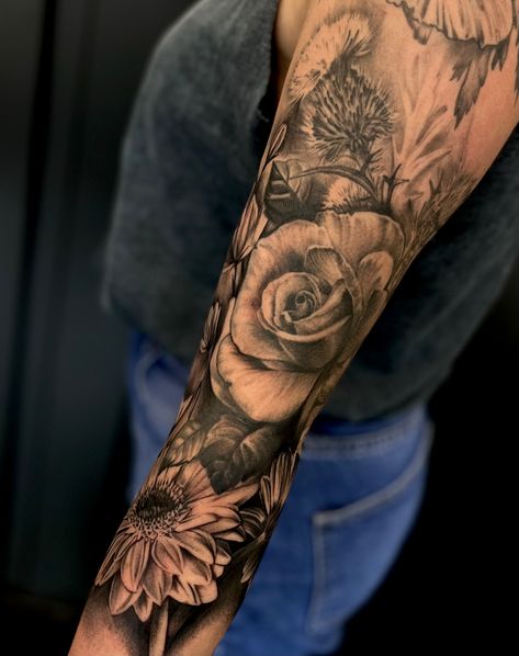 Realism tattoo of flowers on a woman's arm. Black and grey tattoos by Toni Moore Black And Grey Floral Tattoo Shoulder, Black And Grey Half Sleeve Tattoo, Black And Grey Floral Sleeve Tattoo, Realism Flower Tattoo Sleeve, Flower Realism Tattoo, Realism Flower Tattoo, Black And Grey Flower Tattoo, Realism Tattoo Sleeve, Ny Tattoo