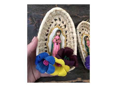 "SET (2) ORNAMENTS   Corn Husk VIRGIN GUADALUPE in a woven basket.  Each Measures approx 6'H x 3 1/2\" x 2\" D.   Super cute ornaments for your Christmas tree or party!  Strung on top for hanging.  Colors of flowers will vary in each piece. Crafted with our partners in Mexico.  We ship through USPS. Our items are made by hand.  Some of them have small imperfections that give them character as a whole.  It simply adds to the uniqueness and rustic quality of the items." Mexican Christmas Party, Virgin Guadalupe, Mexican Christmas Decorations, Pocket Shrine, Mexican Baby Shower, Corn Husk Dolls, Cute Ornaments, Mexican Culture Art, Diy Best Friend Gifts