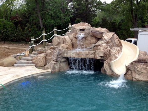 This is a custom faux rock grotto built using RicoRock faux rock products. The slide is from Dolphin Waterslides.  Credit: Grotto application by Jeff at Aquafx, NY. Backyard Pool Grotto Rock Waterfall, Pool Grotto With Slide, Pool With Grotto And Slide, Pool Rock Slide, Pool Designs With Slide, Pool Waterslide, Pool Design Plans, Grotto Pool, Swimming Pool Slides