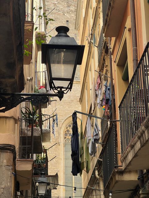 iPhone photo of Barcelona balconies with street lamp, hanging laundry and plants. Gothic church in the background Spain Vintage Aesthetic, Apartment In Spain Aesthetic, Spain Life Aesthetic, Life In Barcelona, Life In Spain Aesthetic, Spain Barcelona Aesthetic, Barcelona Living, Barcelona Spain Aesthetic, Spanish Aesthetic