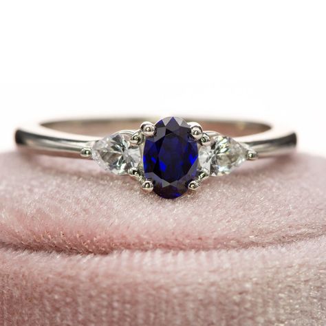 Elevate your engagement with the Tressa - Three Stone Prong Set Oval Lab Sapphire Engagement Ring, featuring a luxurious oval lab-grown blue sapphire as its centerpiece, surrounded by pear-shaped white sapphires on either side. Featuring 2 pear-shaped side white sapphires to frame a deep blue oval sapphire, this three-stone engagement ring embodies timeless beauty and attention to detail. Shop here: https://nodeform.com/products/tressa-three-stone-prong-set-oval-lab-sapphire-engagement-ring-w... Three Stone Sapphire Engagement Ring, Sapphire Wedding Bands, Diamond And Sapphire Ring, Stunning Engagement Rings, Rings Sapphire, Month Of September, Sapphire Wedding Band, Sapphire Engagement Rings, Sapphire Band