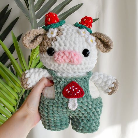 pattern: @crochetcalls🌱 The cottagecore cow🐮🍄🌱✨🍓🌼 I’ve been getting a lotttt of questions on how I created this cottagecore cow, here’s how! Where to find the pattern: This cow is made combining my strawberry cow pattern & my cherry blossom mod🍓🌸 both of these patterns are available in my 10-in-1 fruit cow set on my Etsy only! The mushroom appliqué is a free pattern on YouTube by Pora Pora Crochet🍄 What yarn was used: I used bernat blanket yarn for the cow & chenille home slim for the over... How To Crochet A Strawberry Cow, Crochet Patterns Chenille Yarn, Crochet Mushroom Blanket Pattern Free, Crochet Mushroom Ideas, Christmas Cow Crochet, Bernat Blanket Amigurumi, Chenille Amigurumi Free Pattern, Mushroom Cow Crochet, Cottagecore Amigurumi