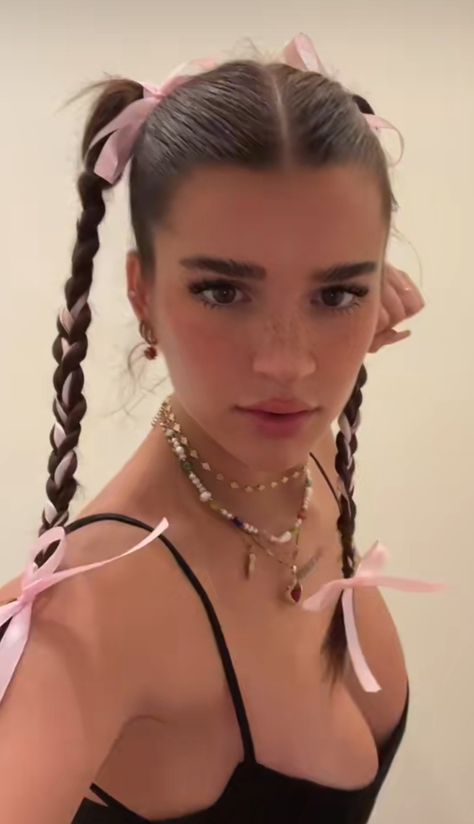 Girl with pink ribbons weaved into two braids and wearing layered pearl jewelry. Y2k Inspired Hairstyles For Long Hair, Bela Hadid Hairstyle, Nyc Hairstyles Street Style, Hair Styles With A Ribbon, Gracie Abrams Ribbon Hair, Jell Hairstyles, Hair Styles Aesthetic 90s, Hairstyles W Ribbon, Space Buns With Ribbons