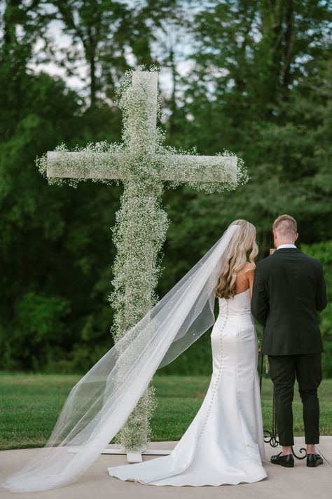 This was the epitome of a classic, southern, summertime wedding. A few rain drops, a lot of sun, a few happy tears, and a LOT of fun! This couple celebrated their classic, romantic wedding at the Commonwealth Event Center of Paducah, Kentucky. The wedding color palette was a classic black and white, with the bridal party wearing black, florals were white, mainly white roses and baby’s breath. A symbolic cross of solely baby’s breath was a magnificent ceremony centerpiece not to be missed. Ceremony Cross Wedding, Cross With White Flowers, Cross Aisle Wedding, Flower Cross Wedding Altars, Cross Ceremony Wedding, Cross At Wedding Ceremony, Wedding Ceremony Cross Backdrop, Flower Cross Wedding, Cross Flowers Wedding