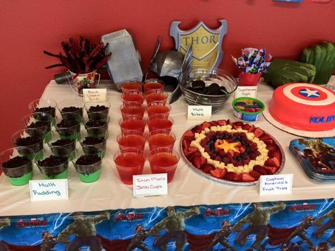 Avengers Birthday Party. Hulk Pudding, Iron Man Jello Cups, Black Widow Twists, Hulk Bites, and Captain America's Fruit Tray. Superhero Jello Cups, Hulk Fruit Tray, Avengers Birthday Party Food, Avengers Party Decorations, Iron Man Party, Avengers Birthday Party, Iron Man Birthday, Jello Cups, Marvel Birthday Party