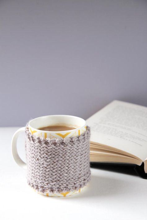 The Gray Days Knitted Mug Cozy will bring a smile to your face on even the gloomiest of days. This easy free knitting pattern will keep the contents of your mug piping hot and you won't burn your hands when you touch it. This simple mug cozy features a garter stitch border and a stocking stitch main body. Plus, this free knitting pattern only requires one ball of double knitting yarn, so you won't need to worry about spending a lot of time or money on this piece. Keeping your tea or other bevera Diy Crochet Hat, Cup Cosy, Mug Cosy, Finger Knitting Projects, Crochet Cardigan Free, Yarn Ideas, Beginner Knitting, Easy Crochet Hat, Knit Ideas