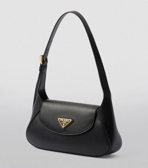 A refined example of timeless leatherwork, this shoulder bag by Prada merges a sleek silhouette with supple leather. Topped with the House’s Triangle motif and offering a choice between being carried by hand or worn over the shoulder, this piece is an evergreen creation with distinctive day-to-night versatility. Cute Purses Aesthetic, Black Designer Bag, Prada Black Bag, Trendy Shoulder Bags, Black Prada Bag, Tas Prada, Small Black Bag, Luxury Bags Collection, Prada Handbag