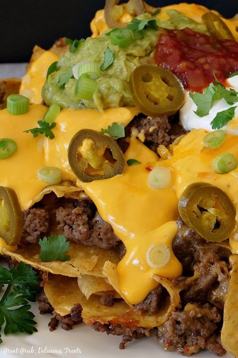 Mile High Nachos are a delicious recipe that is loaded with ground beef, refried beans, nacho cheese sauce, salsa, fresh guacamole, jalapenos, green onions, and cilantro. Velveeta Nacho Cheese, Ground Beef Refried Beans, Nacho Cheese Recipe, Nachos Recept, Loaded Nachos Recipe, Super Nachos, Nachos Cheese Recipe, Nacho Sauce, Nachos Recipe Beef