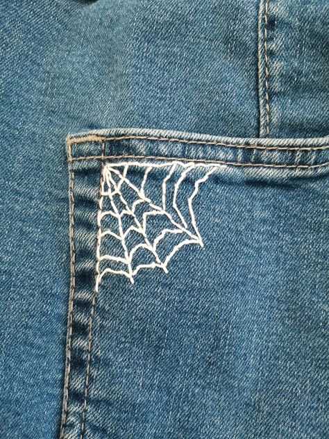 A white spider web embroidery on blue jeans pocket Embroidery On Jeans Tutorials, Jean Pants Embroidery Ideas, Jeans Stitching Ideas, Easy Things To Embroider On Jeans, Fashion Design Embroidery, Things To Sew On Jeans, How To Embroider Spider Web, Sewing Designs On Jeans, Embroider Spider Web