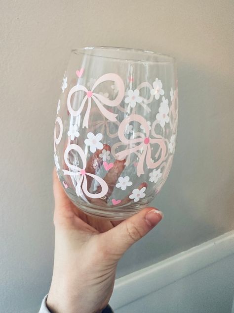 Coquette Wine Glass- Daises- Pink Bows- Gift for Her- Pink Wine Glass- Love- Wine Tumbler- Heart- Wine Gift- Wine - Stemless Wine Glass This 21oz. stemless wine glass is the perfect girly gift! They will be pouring their wine in their new favorite glass! The wording is made from permanent, high quality vinyl.   *Care Instructions- Please hand wash item and DO NOT soak in hot water. DO NOT place in dishwasher. To ensure longevity softly hand wash without scrubbing Bow Wine Glass Painting, Wine Glass Engraving, Wine Glasses Painting Ideas, Drawing On Glass Ideas Easy, Painting Ideas Wine Glasses, Paint Your Own Wine Glass Diy, Wine Diy Gifts, Diy Paint Wine Glasses, Wine Glass Designs Painted