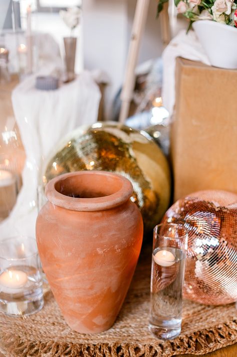 This is a close up of a wedding welcome display. The close up focuses on a terracotta floor vase with disco balls behind it, and atop a jute rug. Floor Vases, Terracotta Floor, Disco Balls, Event Photographer, Floor Vase, Decor Display, Estate Wedding, Vases And Vessels, Planner Design