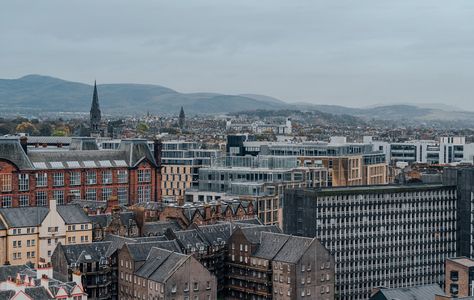 A view of a city with buildings and mountains in the background photo – Uk Image on Unsplash Scotland Street, Uk Images, Fall Images, Orange Wallpaper, Travel Images, Grey Wallpaper, Hd Photos, Architecture Building, Desktop Wallpaper