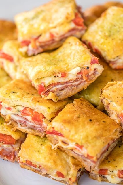 Antipasto Squares recipe - SO GOOD!! Crescent rolls stuffed with ham, salami, pepperoni, provolone, swiss, and roasted red peppers. then topped with a parmesan cheese, egg and pesto mixture and baked. These things are ridiculously good!!! There are never any leftovers when I take these to party! #appetizer #partyfood #crescentrolls Antipasto Squares, Antipasto Appetizer, Football Friday, Crescent Recipes, Square Recipes, Crescent Roll Recipes, Football Food, Party Food Appetizers, Provolone