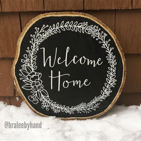 Welcome Home Sign, wood slab, chalkboard paint, white acrylic paint, hand lettered, modern calligraphy, floral wreath design @braleebyhand Wooden Signage, Calligraphy Signs, Floral Wreath Design, Paint White, Wood Slice Art, Wood Door Hangers, Painting Wood, Wall Paint Colors, White Acrylic Paint