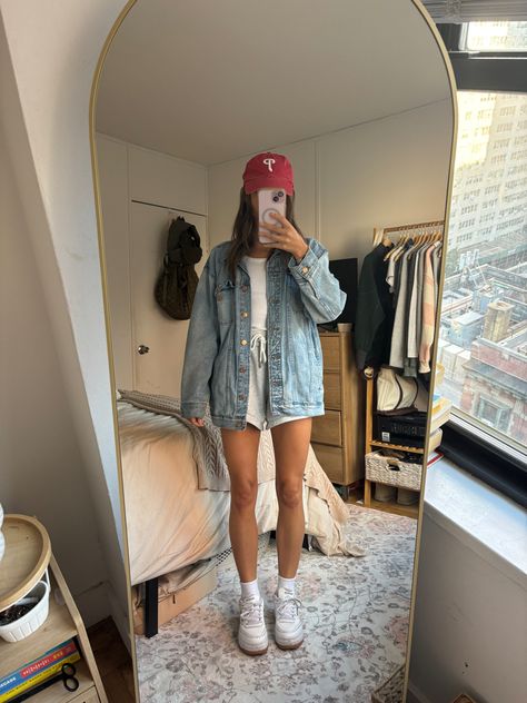 Baseball outfit, Phillies, jean jacket, grey sweatshorts, casual outfit, fall transition, denim jacket, Reebok sneakers Summer Baseball Outfit, Court Legacy Sneaker Outfit, Sporty Outfits For Women Casual, North Carolina Outfits, Reebok Sneakers Outfit, Garage Outfits, Reebok Shoes Outfit, Baseball Outfit Women, Reebok Classic Outfit