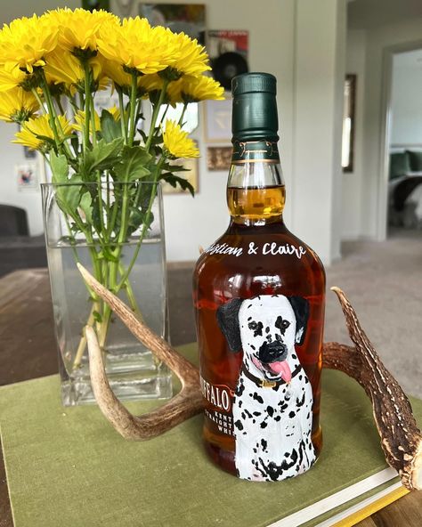 His and hers custom hand-painted bottles for a “Stock The Bar” couples wedding shower! Her bottle: Engagement portrait on the front, ceremony venue on the back (do you recognize this Baton Rouge church!?), and chinoiserie-inspired magnolia branches on a gold leaf background🥂 His bottle: A pet portrait of their Dalmatian, Aldo, painted on his favorite bottle of bourbon. Simple and sweet🥃 Now this couples’ bar is stocked with two original pieces of art that make for great sipping, too! Pers... Painted Whiskey Bottles, Bourbon Bottle Painting, Painted Woodford Reserve Bottle, Hand Painted Champagne Bottle Engagement, Hand Painted Tequila Bottles, Magnolia Branch, Hand Painted Bottles, Couple Wedding Shower, Leaf Background