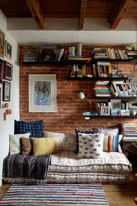 "The key for us has been to maximize the small space we have as much as possible (i.e. the second floor landing is now a play kitchen area and a reading nook where before it was just an office)..." In the reading nook, the mattresses are from Urban Outfitters, the shelves are IKEA, the lamp is vintage, the rug is from Land of Nod and the black and white blanket is RCVA. The block print above the daybed is by Laura Murdoch. Små Rum Lidt Plads, A Reading Nook, Small Bedrooms, Decor Ikea, Design Del Prodotto, Reading Corner, Reading Nook, Brick Wall, 인테리어 디자인