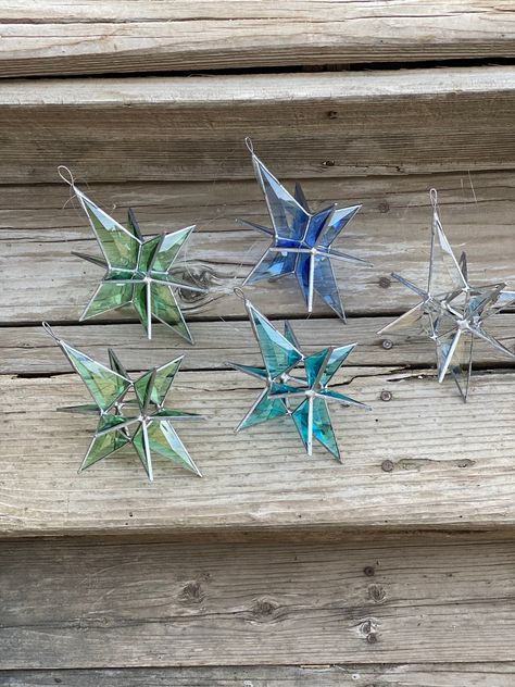 These beautiful beveled stars are a wonderful addition to your home. They can be hung from a ceiling fan, a curtain rod, or any place that has direct sunlight. In direct sunlight the glass with throw light prisms around the room! The stars are approximately 8" by 5". They can be strung with fishing line as long as there are multiple knots or with a chain. Our copper foiled and leaded stained glass pieces contain lead. After handling please wash hands and keep away from children and pets! Stainglass Ornaments, Stained Glass Star, L'art Du Vitrail, Slumped Glass, Hand Blown Glass Art, Vert Turquoise, Blown Glass Art, Stained Glass Christmas, Glass Stars