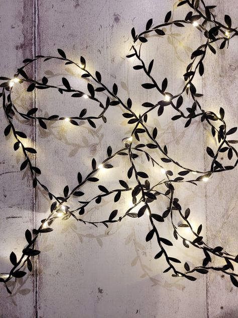 Black Gothic Leaf Fairy Lights 🖤 This gothic black leaf fairy light garland with warm white mini LEDs is perfect for your alternative home, wedding or spooky Halloween event decor. ✨ They look great as witchy table decor centerpiece, wrapped around a staircase, hanging off a modern monochrome bookshelf or adorning a dark cottagecore bedroom headboard. They are a wonderful cosy way to decorate that can be left up all year round! Monochrome Bookshelf, Halloween Event Decor, Witchy Table, Dark Cottagecore Bedroom, Fairy Lights On Wall, Fairy Light Garland, Wedding Table Lighting, Leaf Fairy, Cottagecore Bedroom