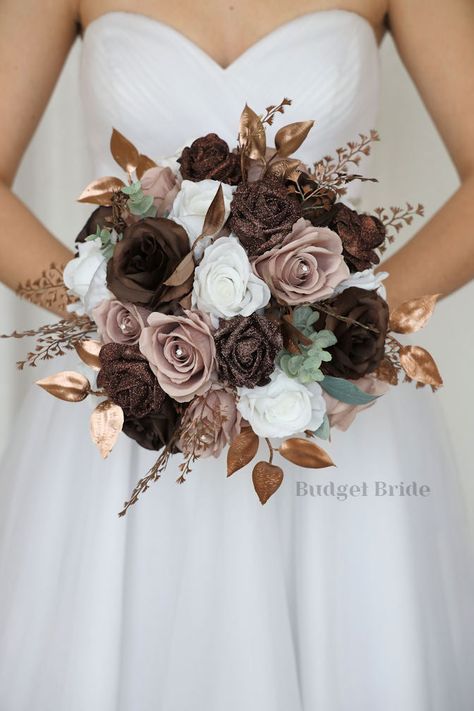 This magnificent rounded brides’ bouquet is crafted using mauve, brown and white roses of the highest quality. This elegant bouquet is sure to leave a lasting impression. The delicate brown glitter roses in this collection, create a bright and dazzling arrangement that is sure to turn heads. With a mixture of gold foliage and greenery this bouquet is sure to make a statement. All of our bouquets are a wonderful option for destination weddings, as they can be bought in advance and easily stored a Bronze And Cream Wedding, Brown Bouquet Wedding, Dusty Rose And Brown Wedding, Brown Aesthetic Wedding Theme, Brown And Rose Gold Wedding, Brown And Ivory Wedding, Brown And Gold Wedding Theme, Shades Of Brown Wedding, Mocha Wedding Theme