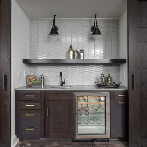 White backsplash for wet bar. The wet bar has wooden cabinets, wooden open shelves, wooden sliding doors, and dark sconces. The wet bar is perfect for entertainment. Photography by The Home Aesthetic. Open Bar Basement, Wet Bar In Living Room Built Ins, Basement Bar Dark Cabinets, Basement Bar Backsplash, Wet Bar Backsplash Ideas, Bar Backsplash Ideas, Bar With Floating Shelves, Wet Bar Backsplash, Basement Tile