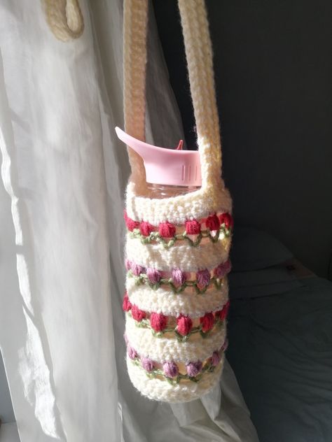 Creamy white wool water bottle holder striped with lilac-pink and red tulips with light green leaves. Inside is a bottle with a pink cap. Tulip Water Bottle Holder, Crochet Tulip, Water Bottle Holder, Water Bottle Holders, Bottle Holder, Bottle Holders, Diaper Cake, Straw Bag, Straw